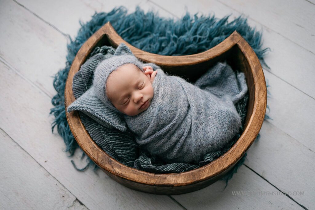 Baby boy in a moon prop for photography newborn session